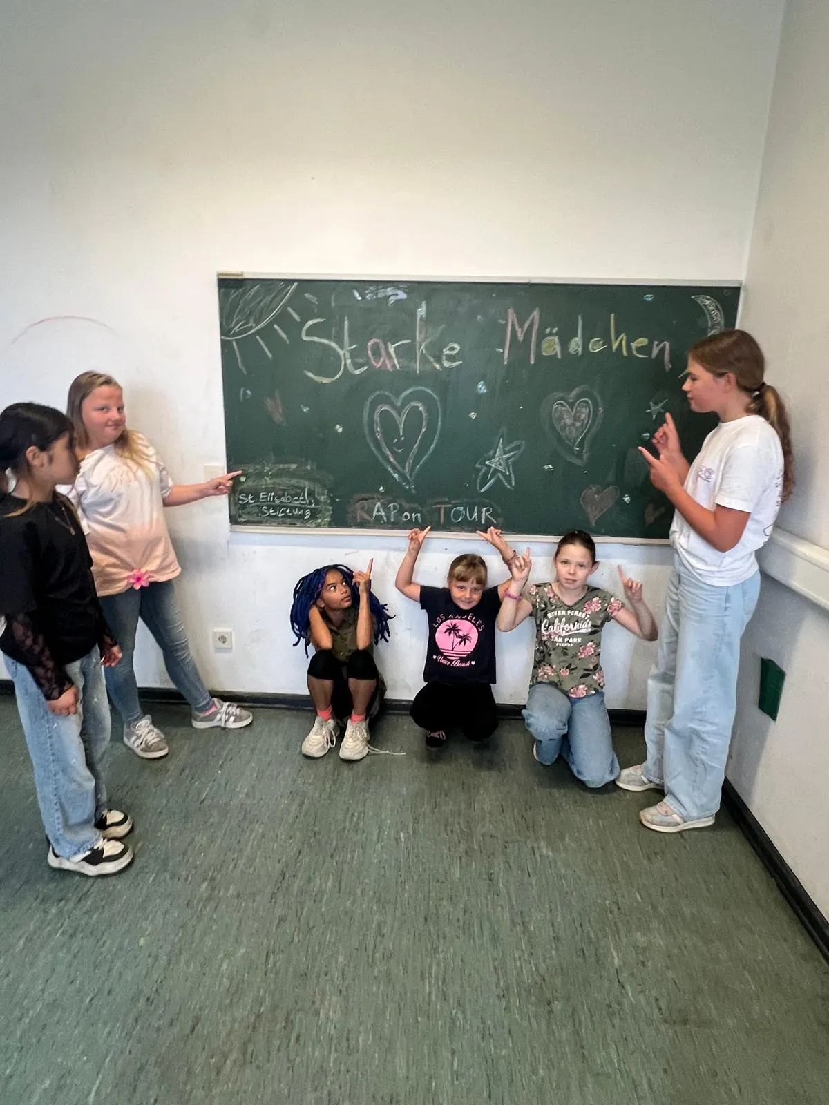 Mädchen vor der Tafel mit Starke Mädchen, St. Elisabeth-Stiftung und RAP ON TOUR