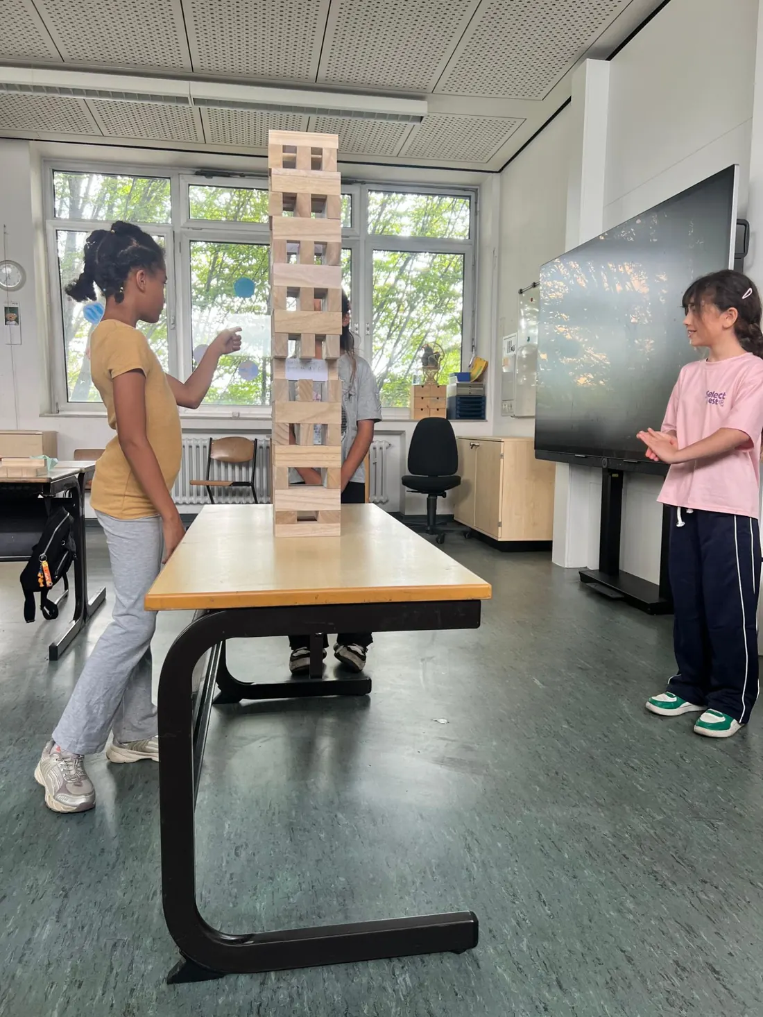 Mädchen bauen gemeinsam einen Turm aus Holzklötzen